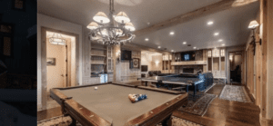 a pool table and a chandelier above it
